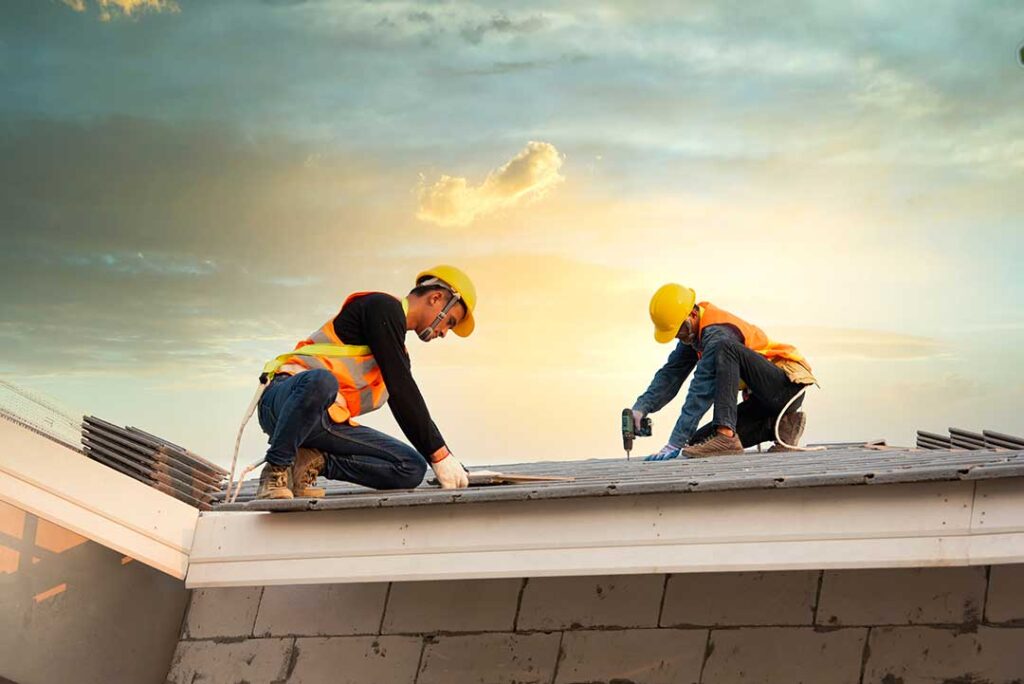 A homeowner reviews paperwork and calculator while planning for a home roof replacement.