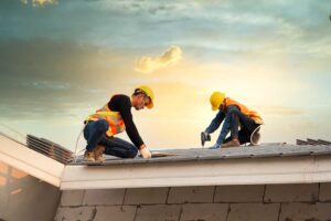 A homeowner reviews paperwork and calculator while planning for a home roof replacement.